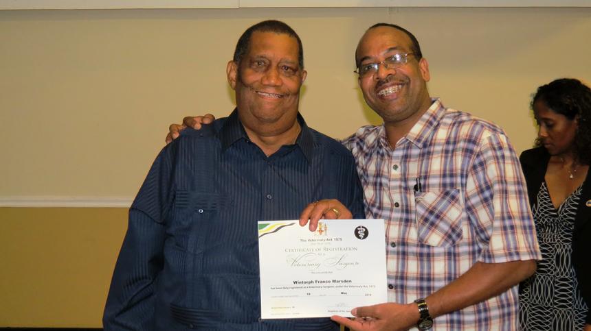 A newly registered veterinarian receiving a Jamaica Veterinary Board registration certificate