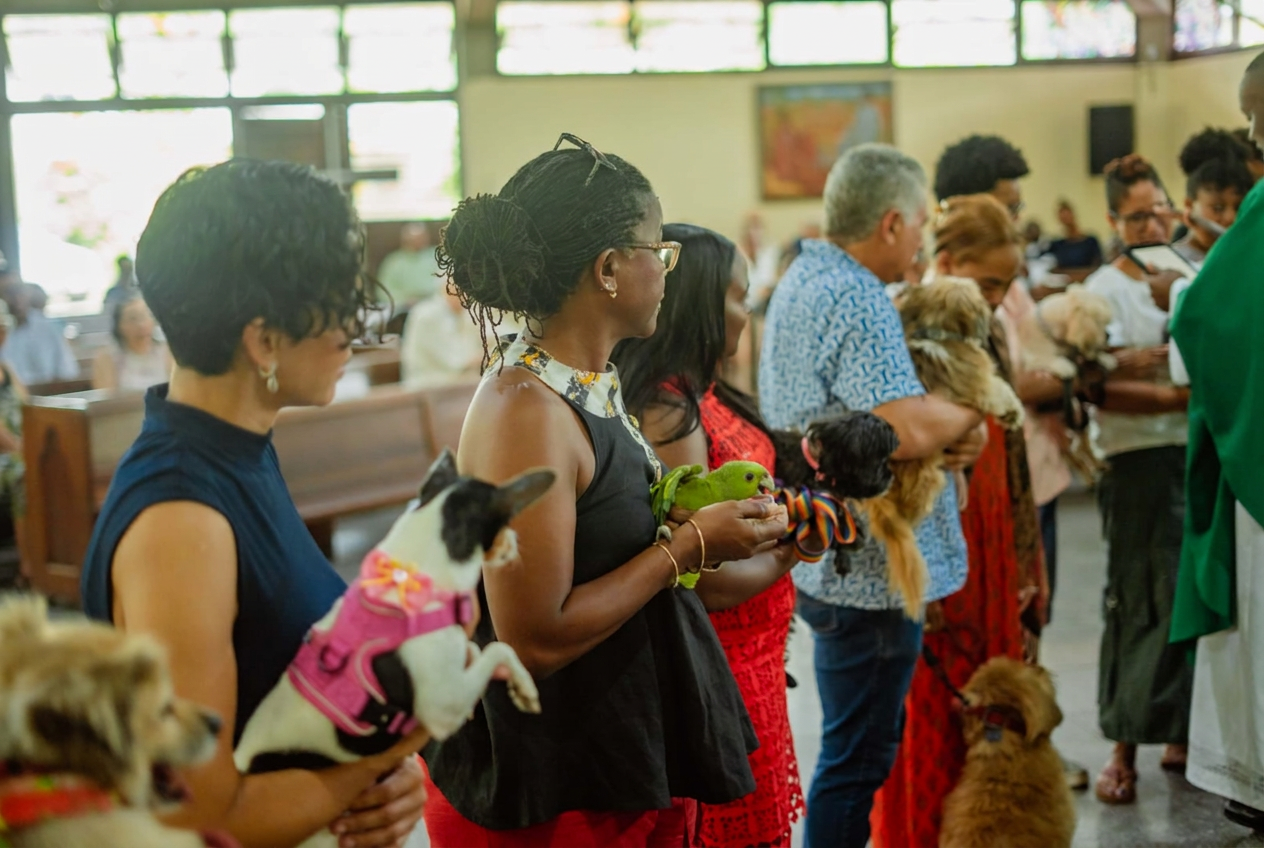 Attendees holding dogs and a parrot during the JVMA anniversary service